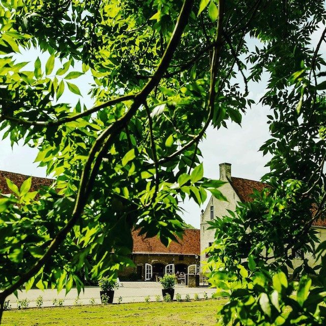 De hoeve gezien door de bomen